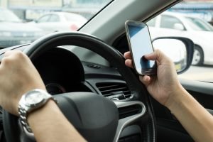 החזקת טלפון נייד בזמן נהיגה – עבירה או לא ?